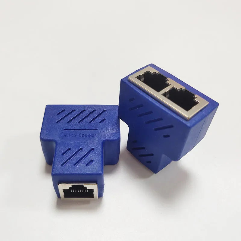 Two white RJ45 three-way network tee splitters on a table.