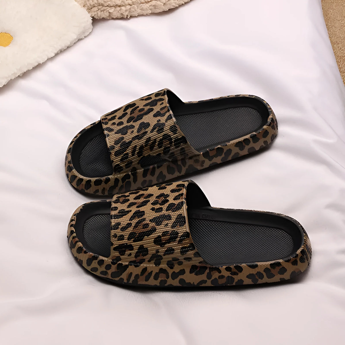 Women's leopard print slippers with thick EVA sole in black, pink, khaki, and white zebra print.