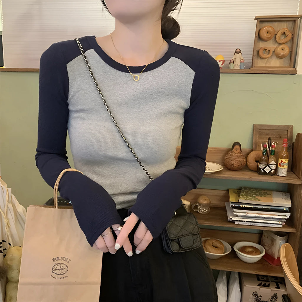Women's black viscose top with embroidery and long princess sleeves on a hanger.