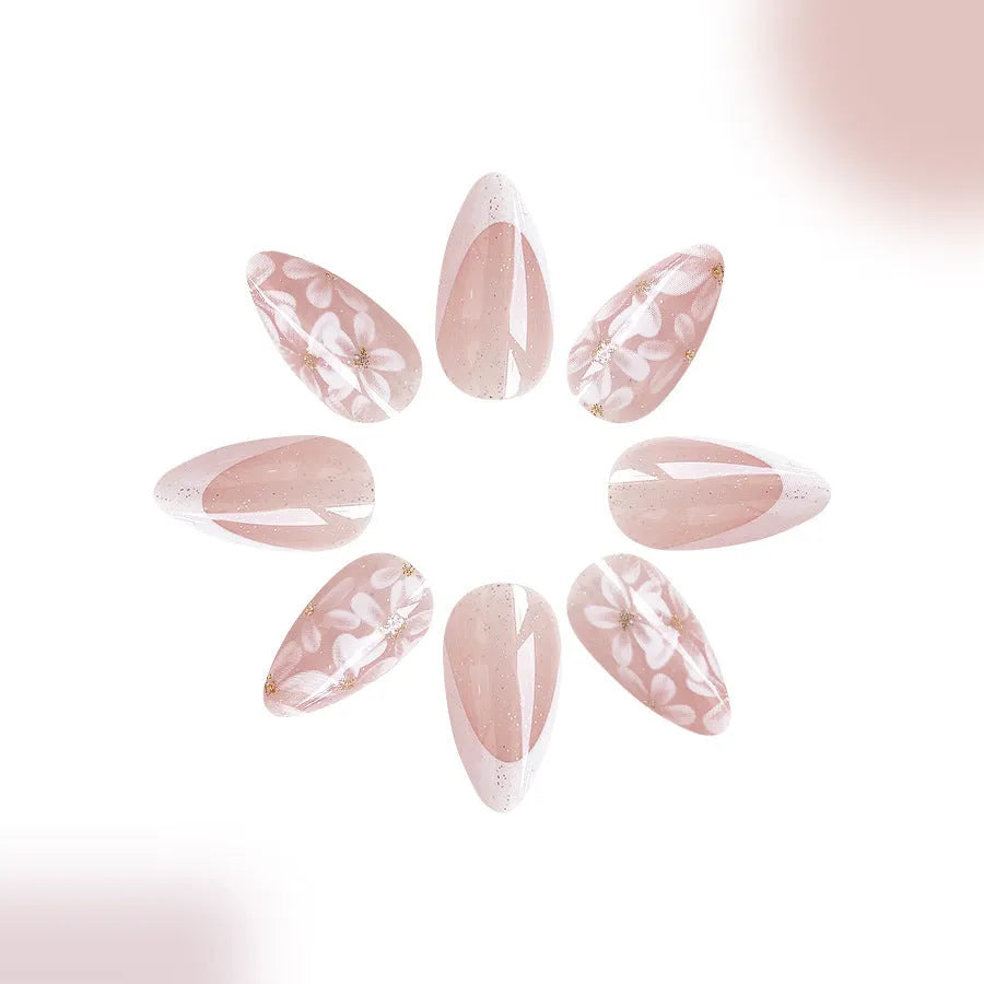 Short almond-shaped false nails with French style base and glitter powder flower decoration, colour C625.