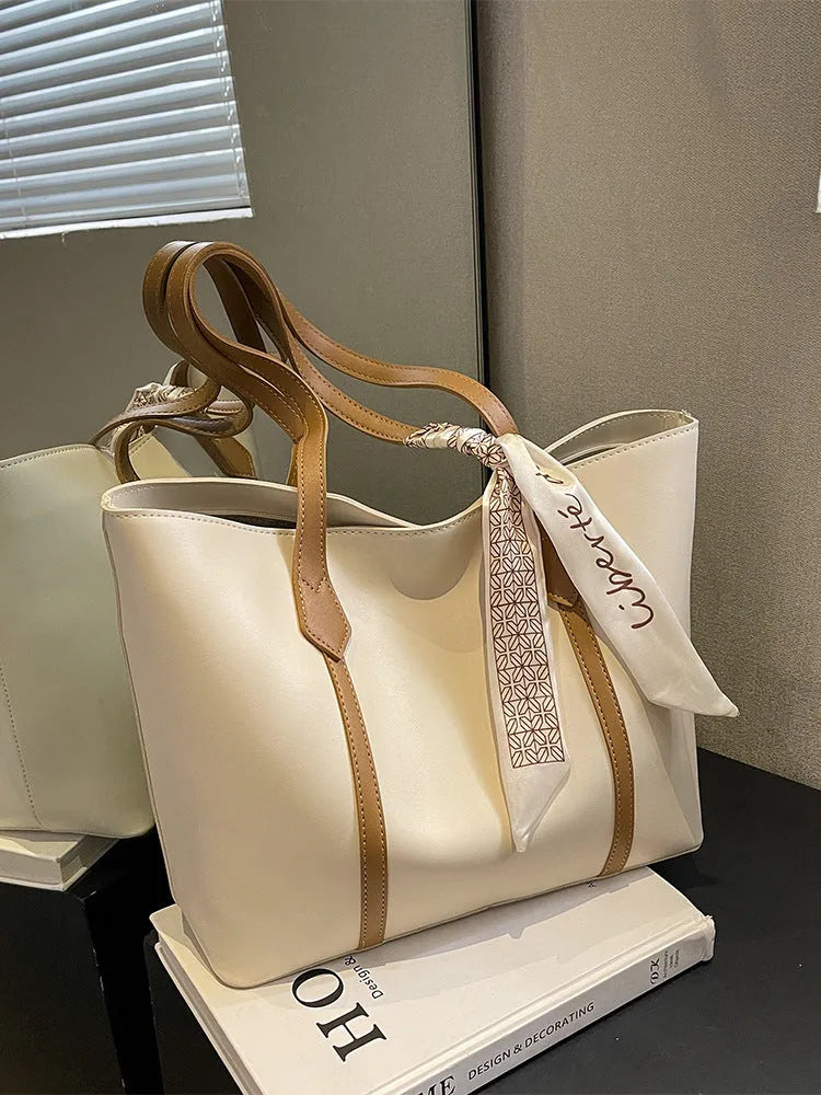 Large soft tote bag in bucket style with crossbody strap and sewing line detailing