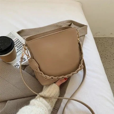 Khaki PU woven one-shoulder crossbody bucket bag with retro design on a mannequin
