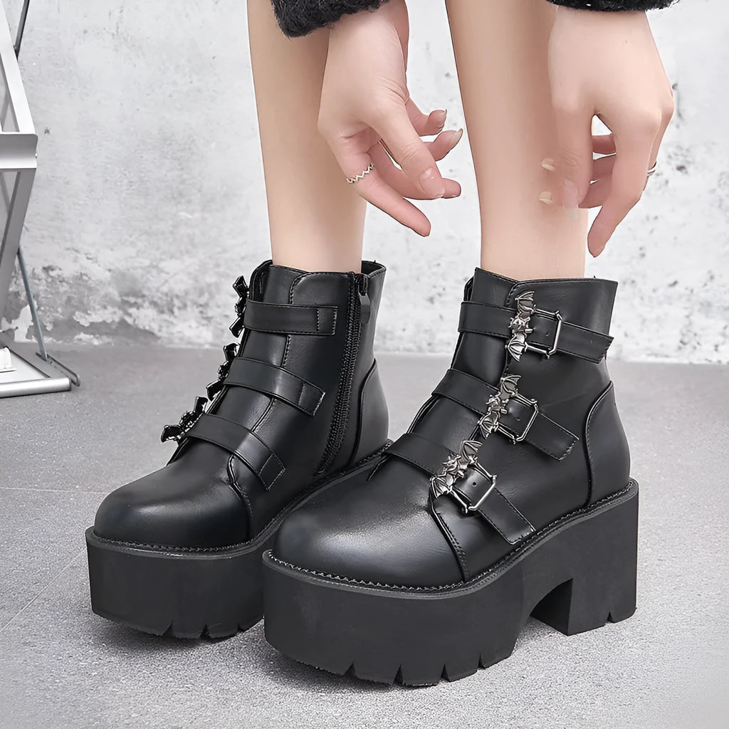 Black women's punk style short boots with bat buckle, thick heel, and side zipper.