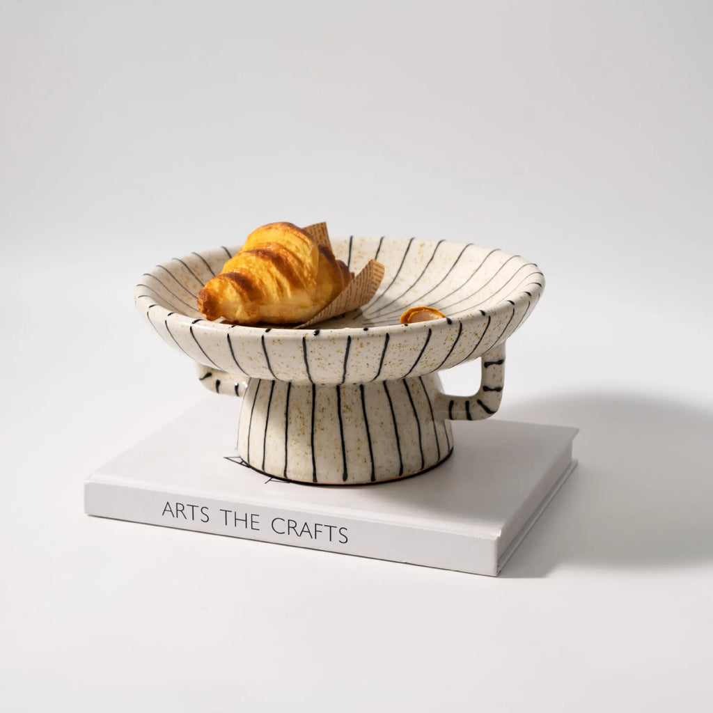 Black and white striped synthetic resin dessert plate on a table.