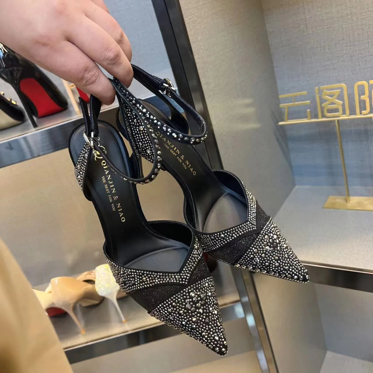 Women's silver hollow high heels with stiletto heel, pointed toe, and red sole on a plain background.