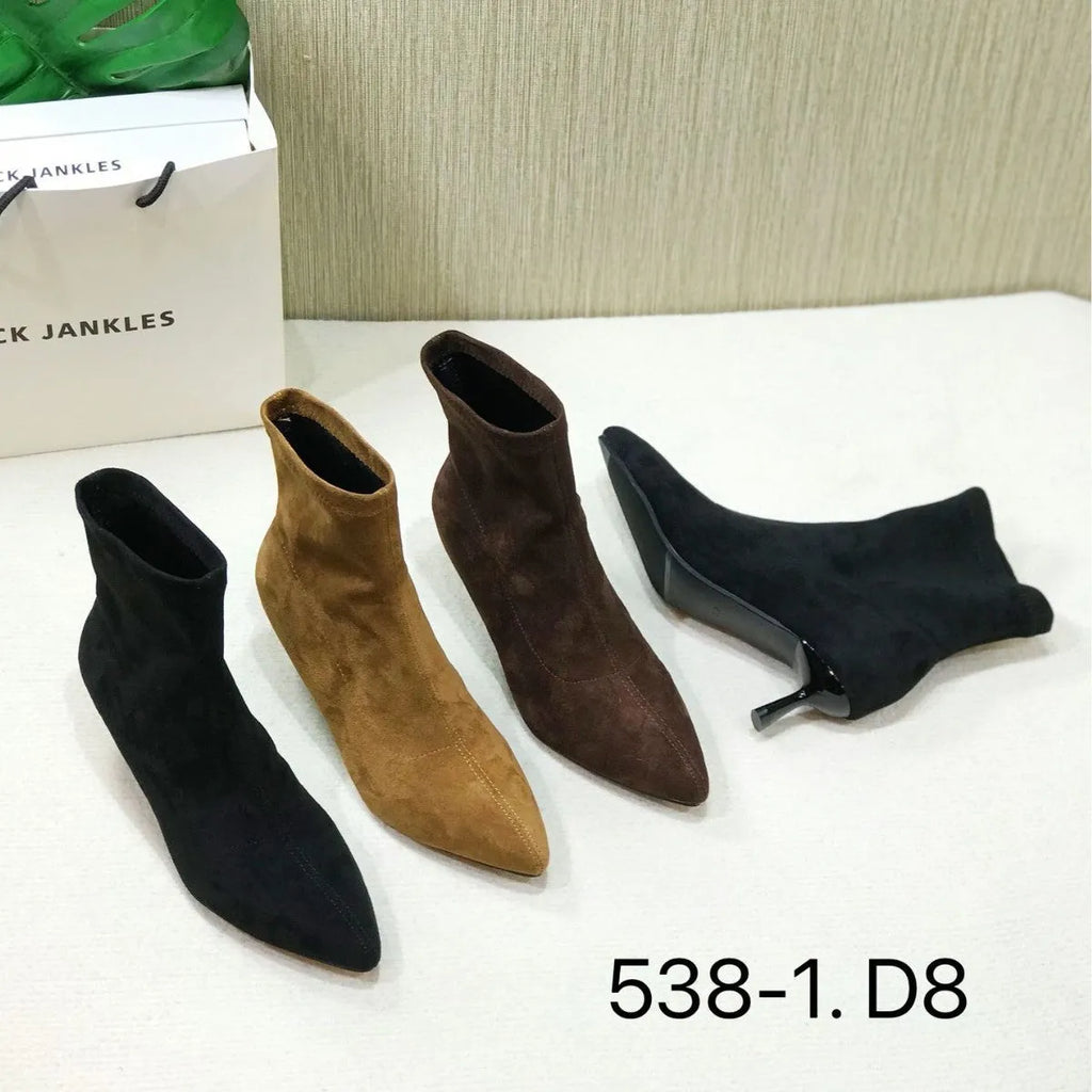 Black pointed toe women's ankle boots with a stiletto heel on a plain background