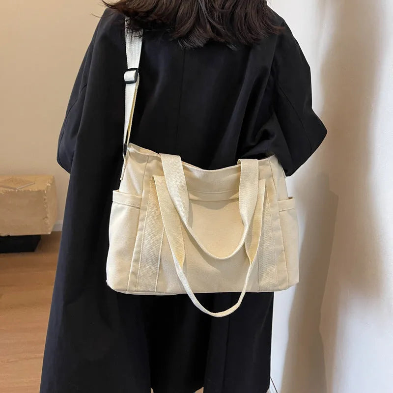Solid colour polyester tote bag with large capacity and a mobile phone pocket.