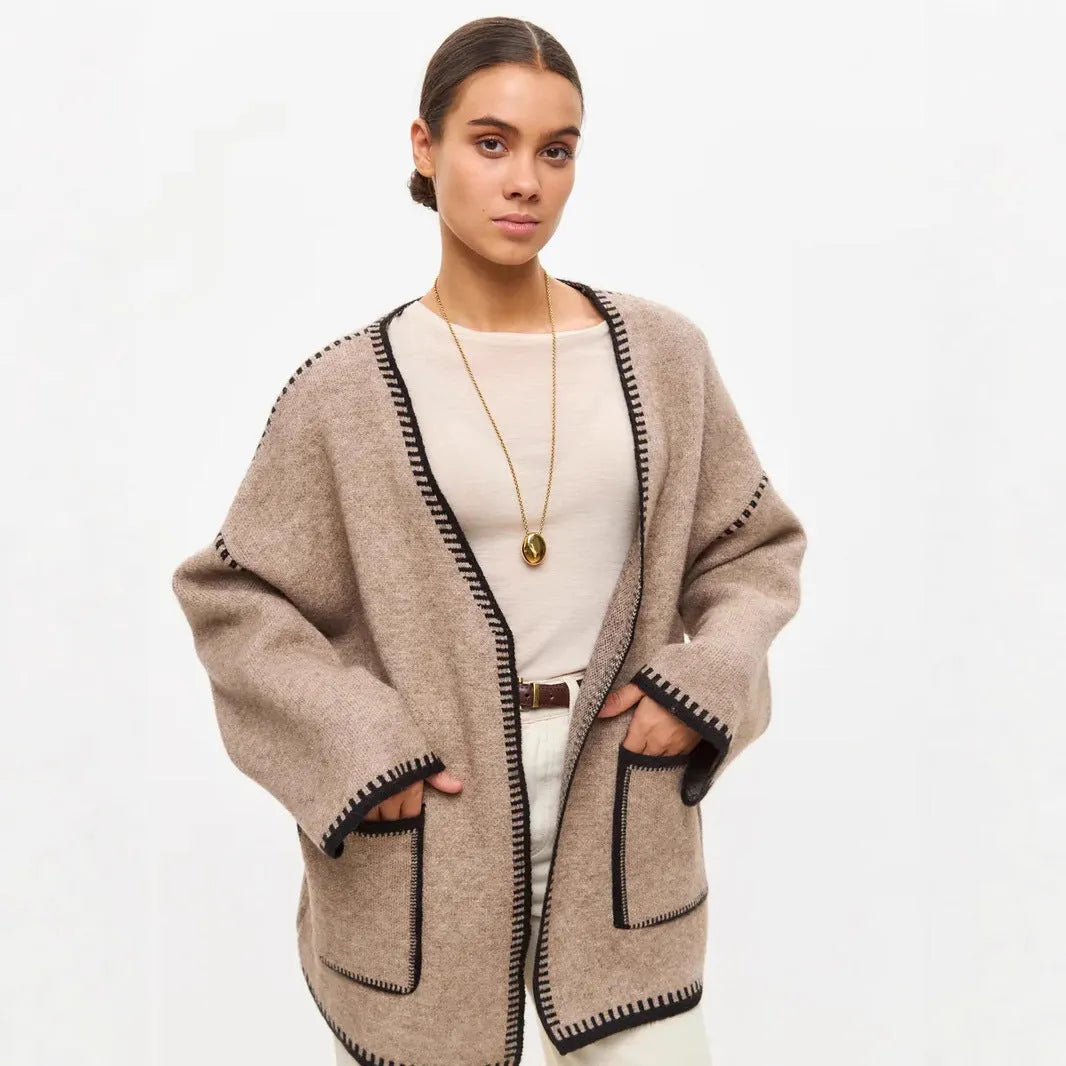 Loose mid-length knitted cardigan sweater coat with a lace-up front, shown in a neutral colour.