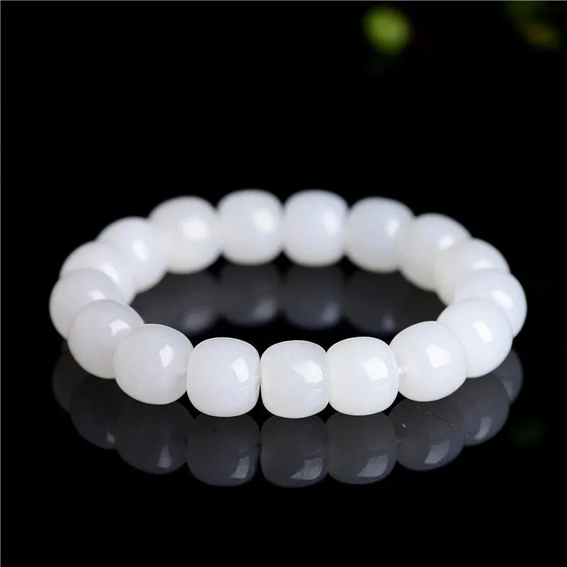 White Hetian jade barrel bead bracelet for men and women on a wrist.