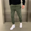 Man wearing light blue baggy straight-leg casual pants with patch pockets and an elastic waistband.