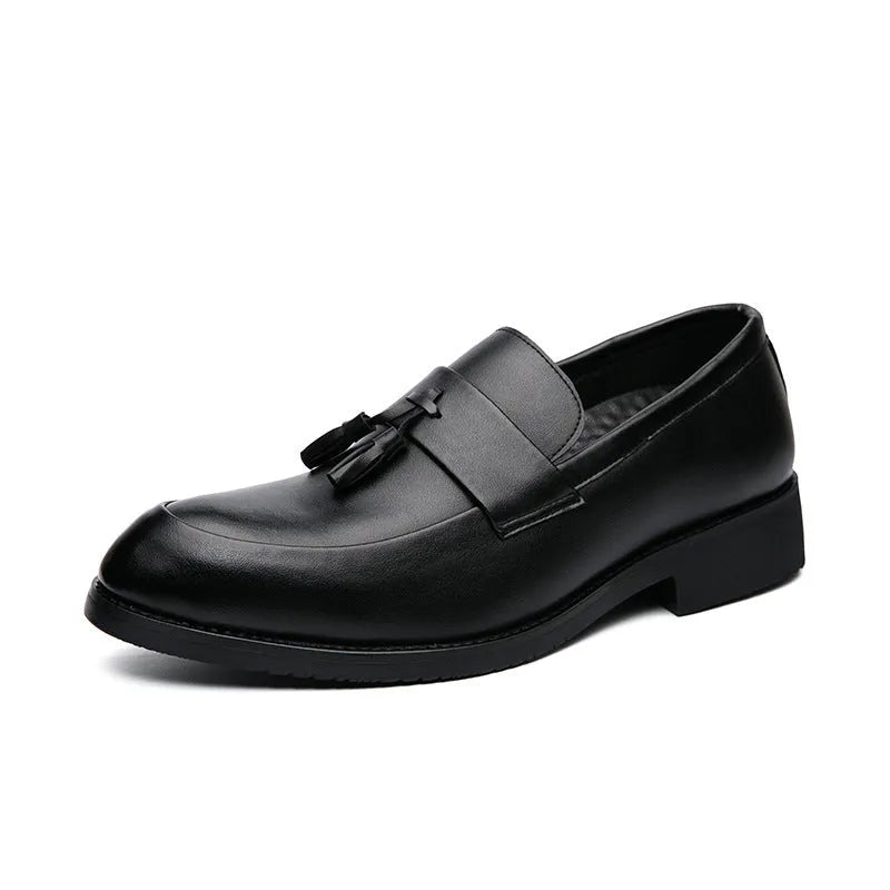 Men's black tassel slip-on loafers with a pointed toe and rubber sole on a white background.