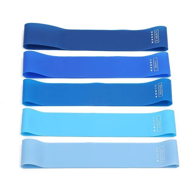 Set of five colour-coded TPE yoga tension straps laid out side by side, showing green, blue, yellow, red, and black options.