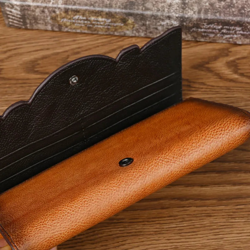 Women's brown embossed floral pattern tri-fold cowhide leather wallet showing interior compartments