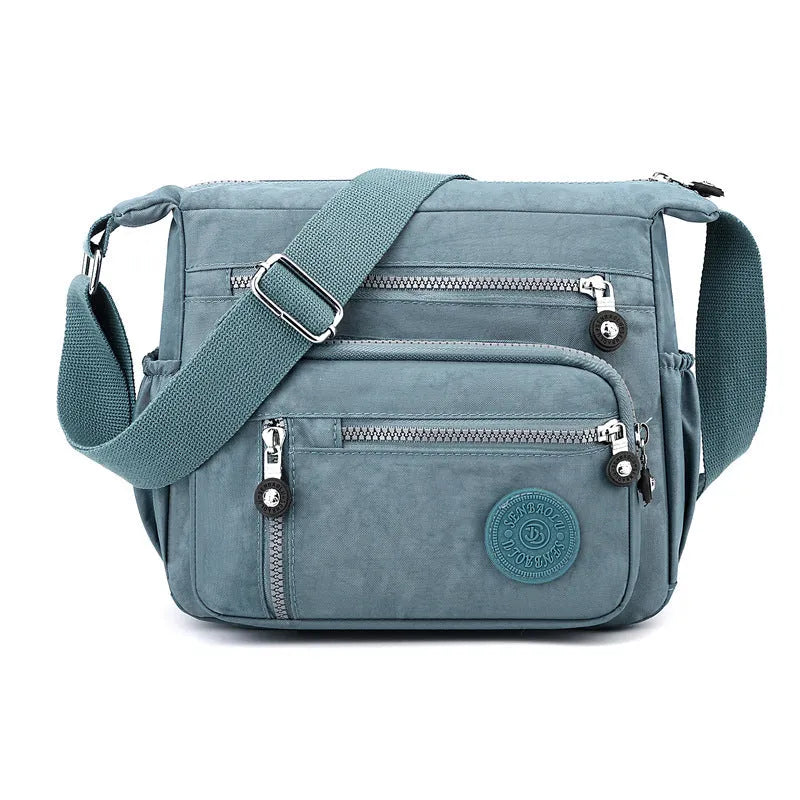 Grey nylon messenger bag with single shoulder strap showing square vertical shape and lining interior