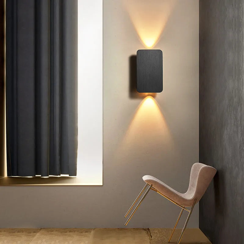 Minimalist modern wall lamp with a slim metal frame in a choice of four finishes, mounted on a wall.
