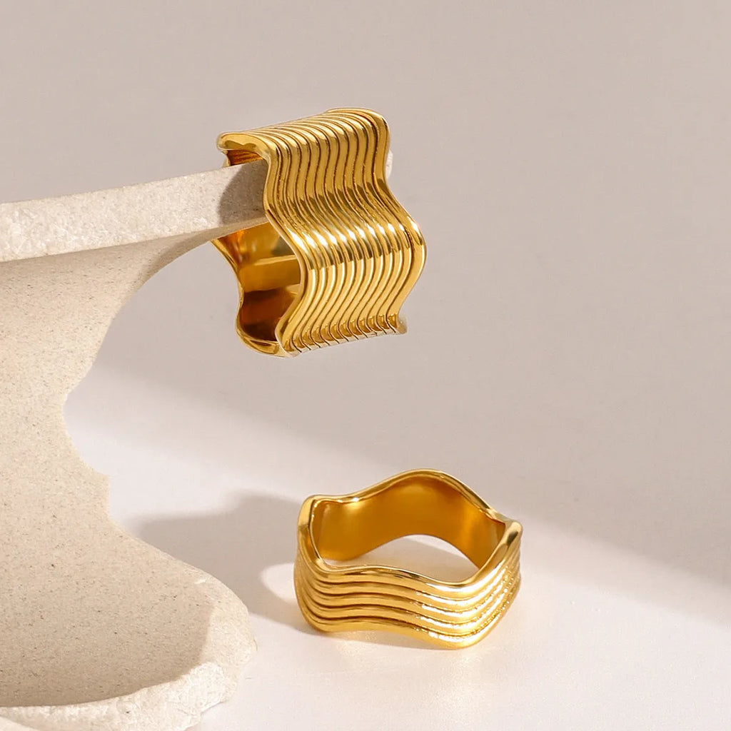 A geometric wave-design ring for women made from silver-toned stainless steel.