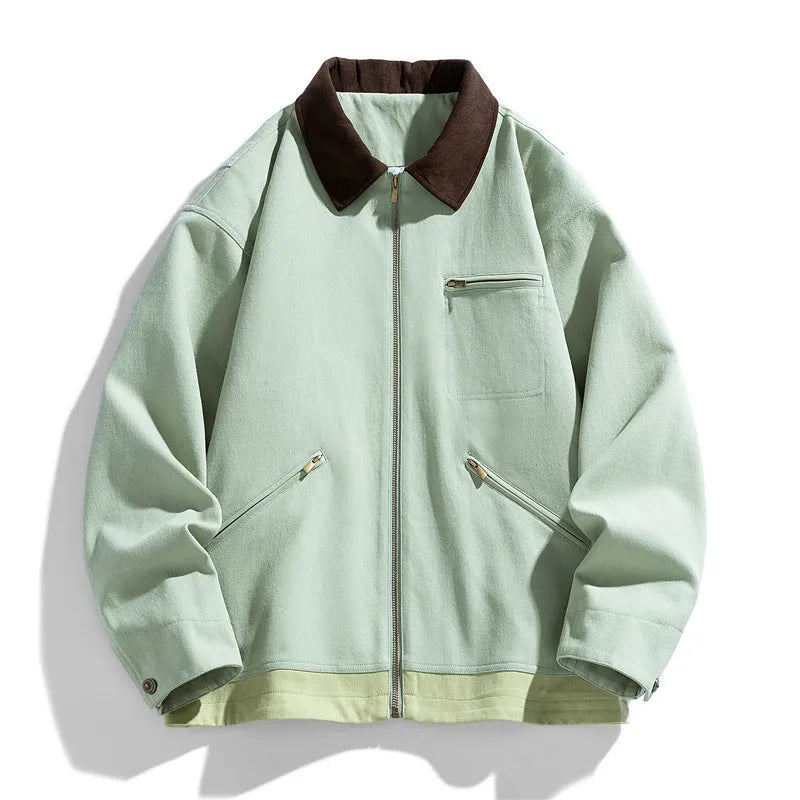 Man wearing a loose-fit mint green retro workwear jacket with contrast lapels and side pockets.