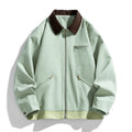 Man wearing a loose-fit mint green retro workwear jacket with contrast lapels and side pockets.