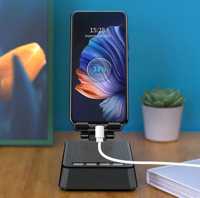 Black mobile phone stand with integrated Bluetooth speaker and microphone on a desk