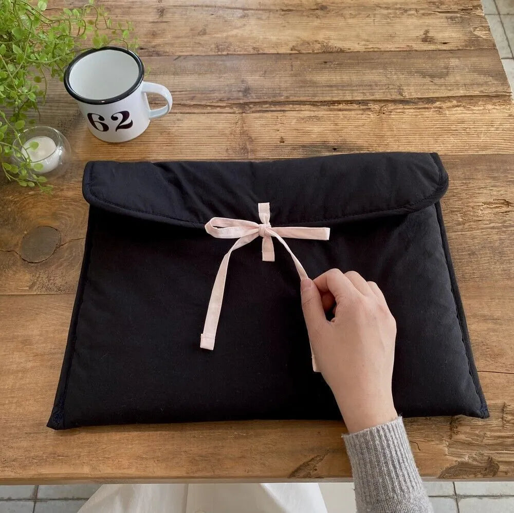 Women's black quilted laptop bag with ballet bow detail and striped pattern