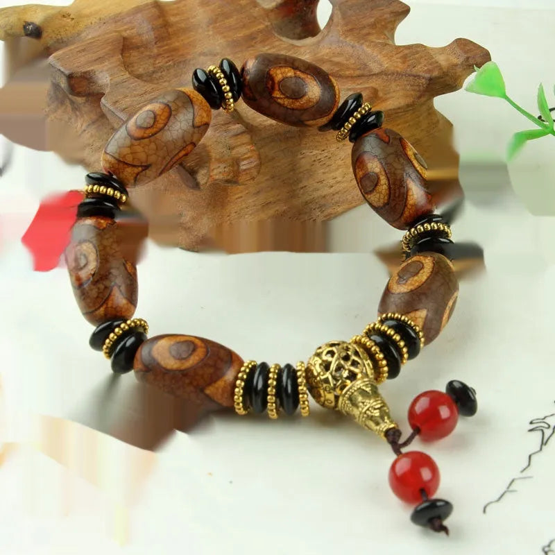 Distressed agate bracelet with traditional Tibetan dzi beads including three-eye and Nine Eyes designs.