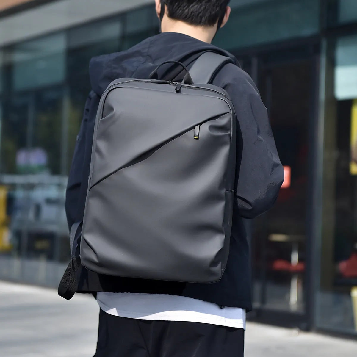Large waterproof PU leather backpack for men with visible stitching details in black colour