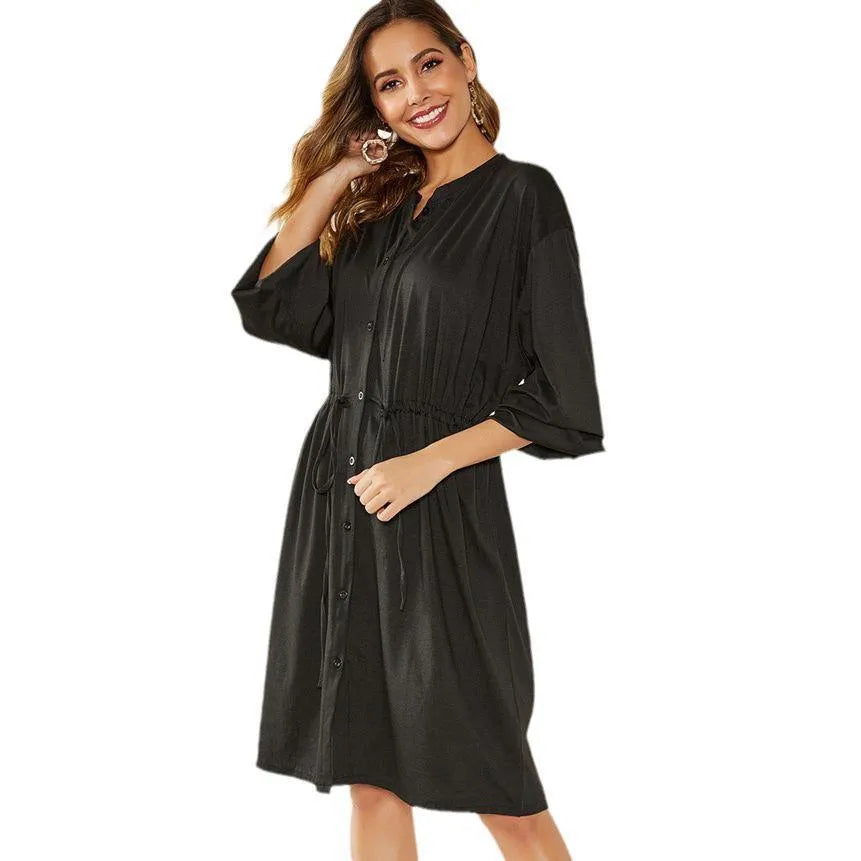 Women's loose elastic belt cinched short dress in solid black or red polyester with long sleeves and A-line skirt