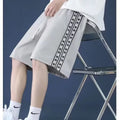 Men's black baggy track pants with elastic waistband on a neutral background.