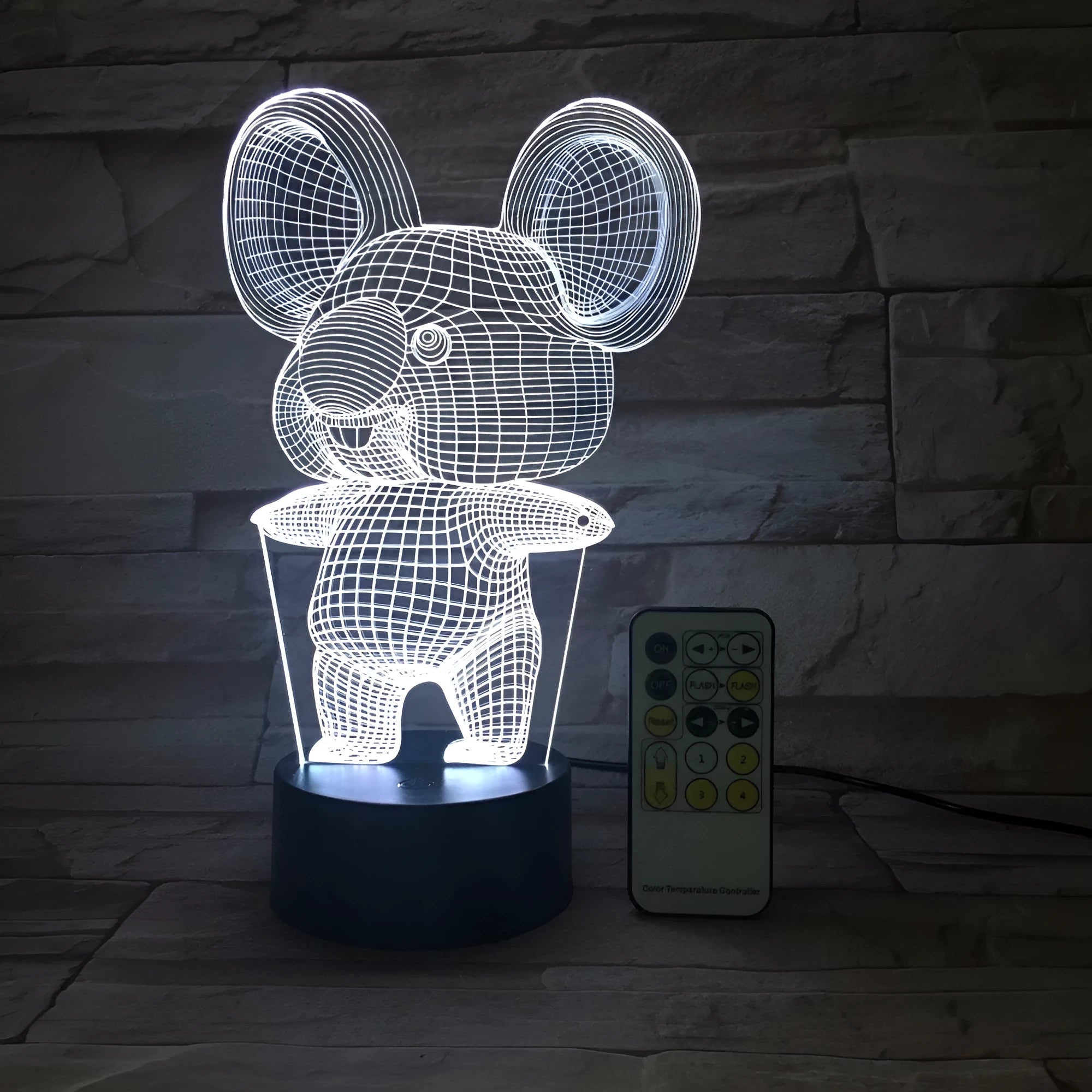 Black koala-shaped LED night light with remote control on a white surface