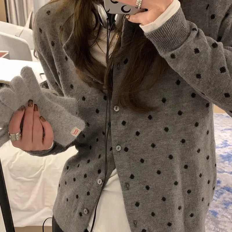 Grey women's knitted cardigan with a crocheted flower decoration on the front.