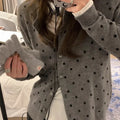 Grey women's knitted cardigan with a crocheted flower decoration on the front.