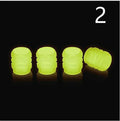 Set of luminous rubber tyre valve caps in assorted colours on a car wheel valve stem.