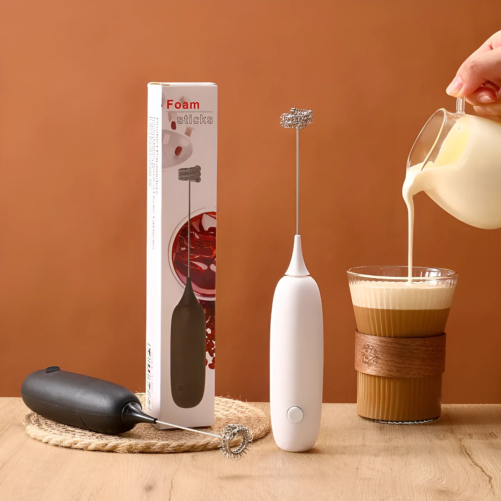 Hand-held electric milk frother in black and white colour options