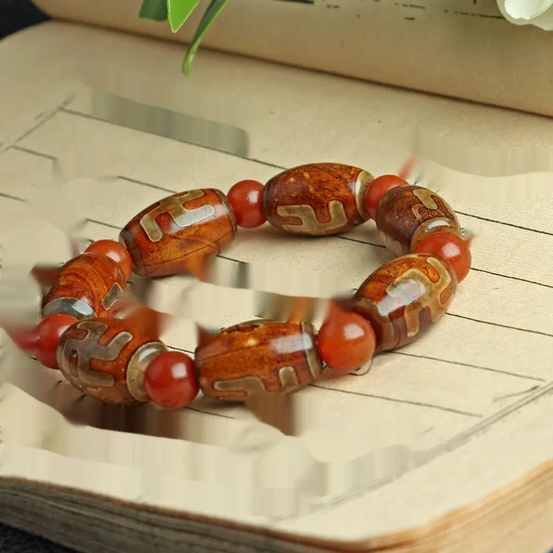 Distressed agate bracelet with traditional Tibetan dzi beads including three-eye and Nine Eyes designs.