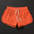 Men's loose beach surfing shorts in orange, fluorescent green, and black colors with elastic waistband