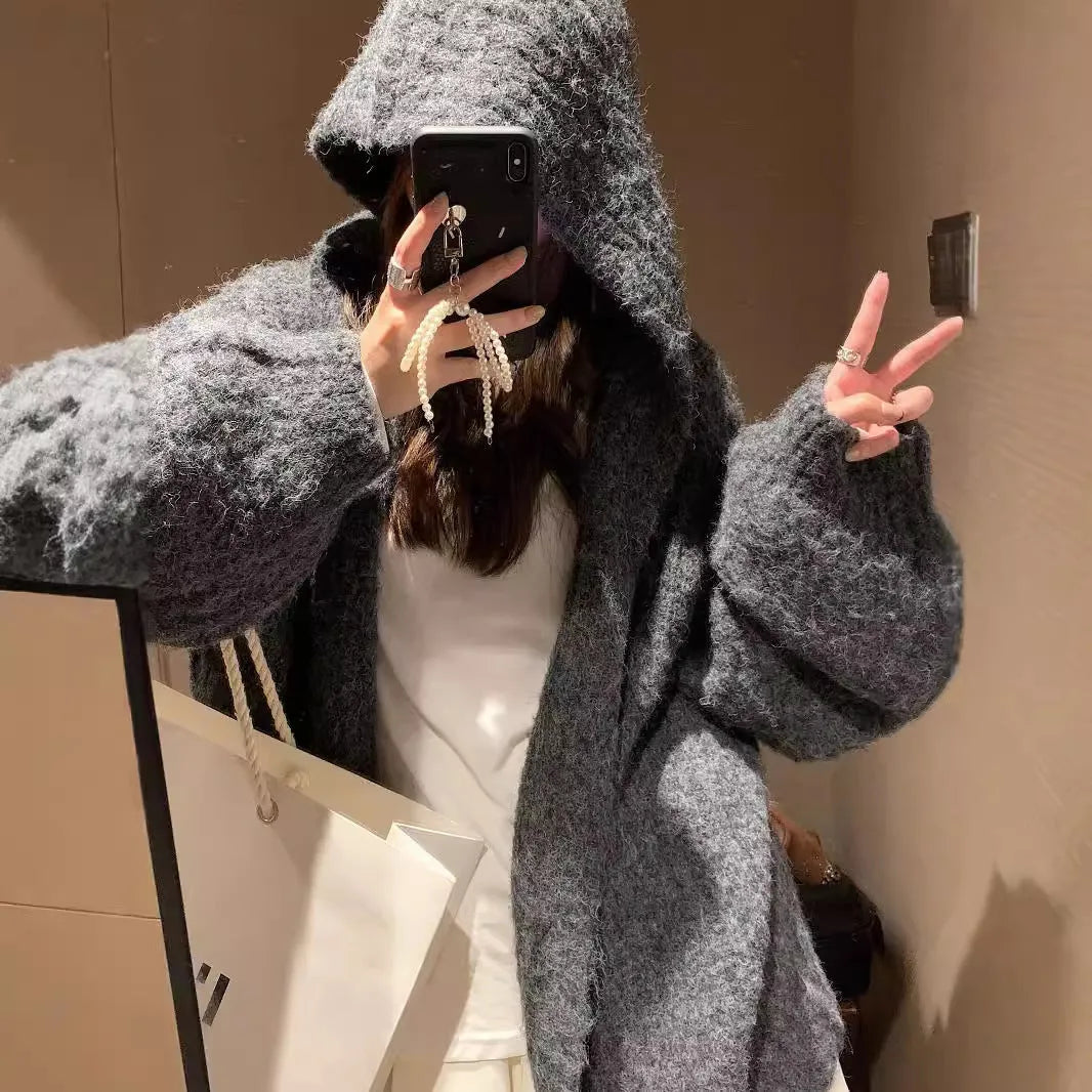 Women's dark grey loose-fit hooded acrylic sweater cardigan on a hanger