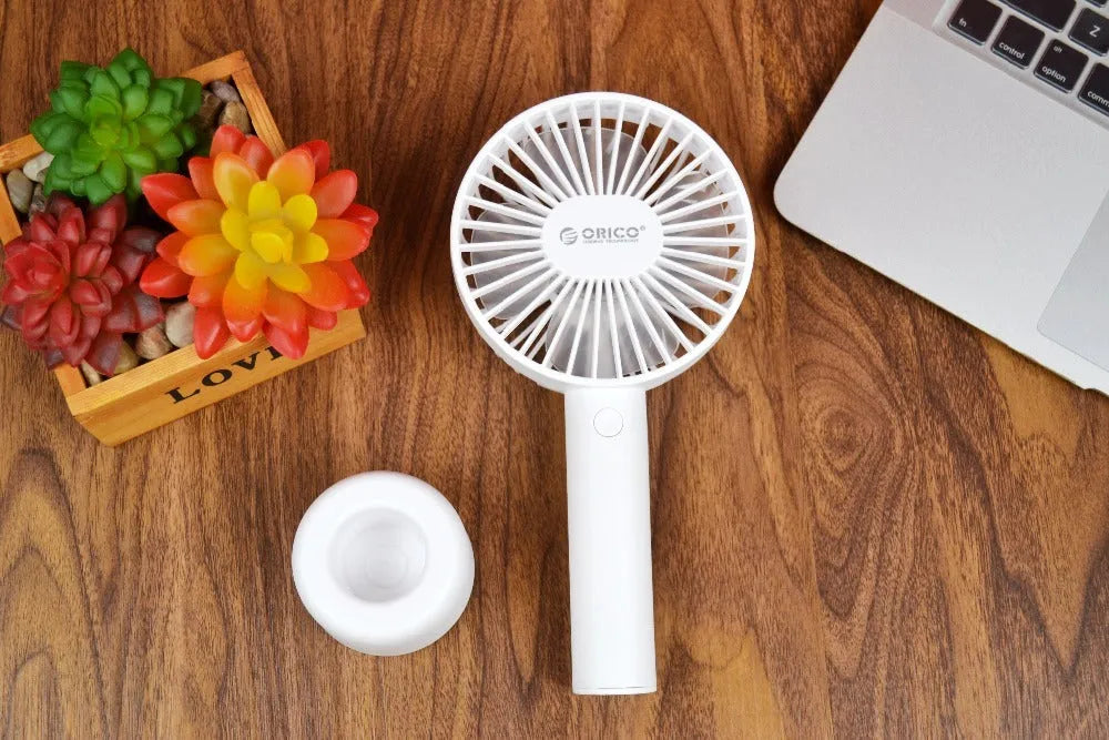 White ORICO FH1 portable USB desk fan with fine-line texture, shown as a handheld and desktop unit.