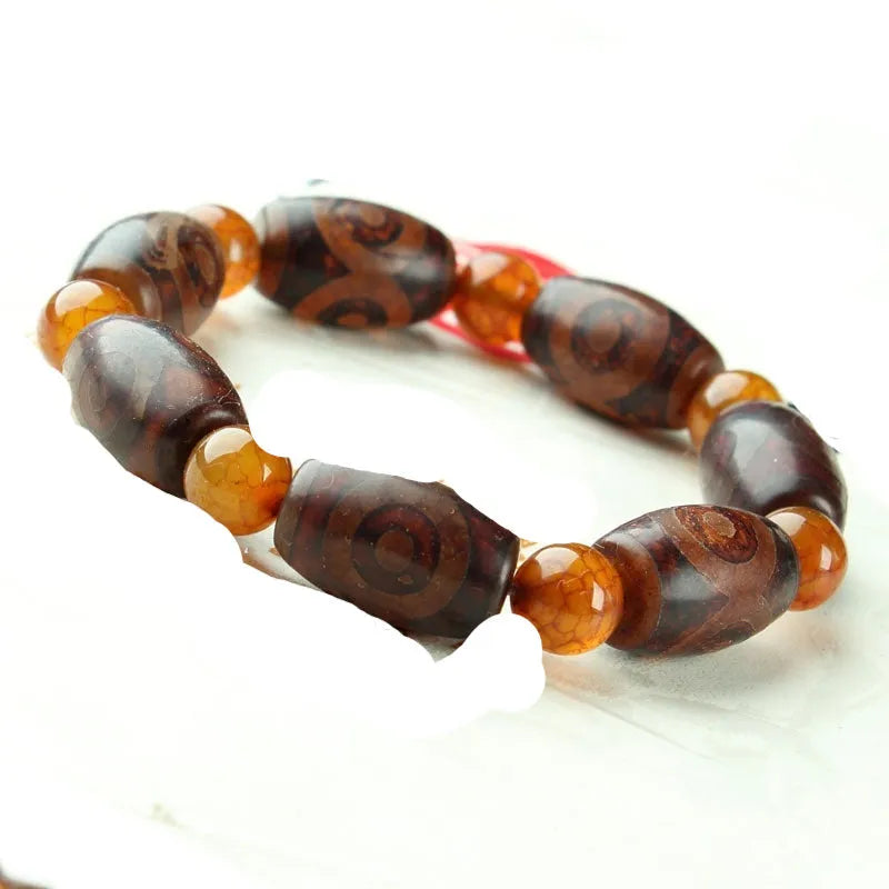 Distressed agate bracelet with traditional Tibetan dzi beads including three-eye and Nine Eyes designs.