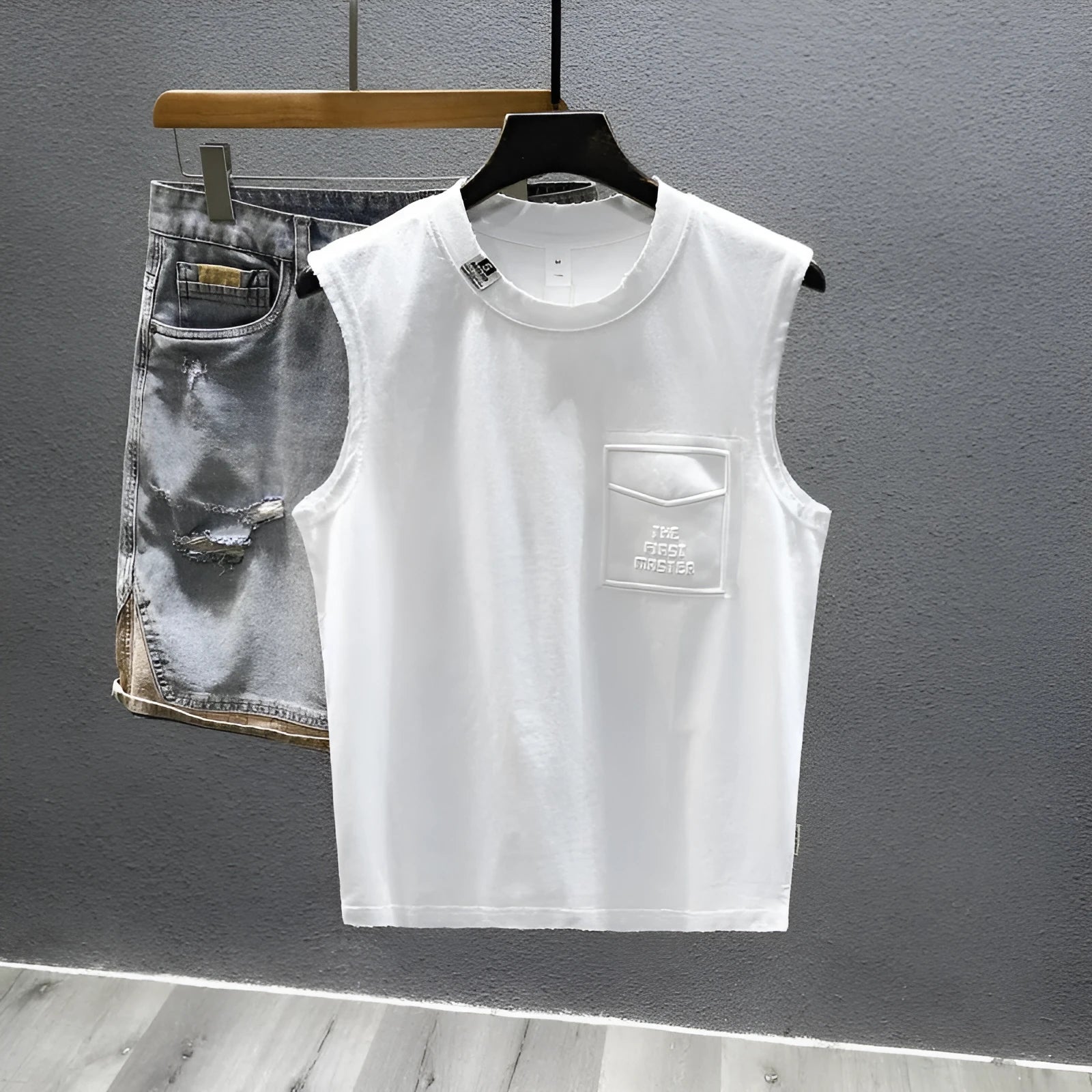 Loose fit cotton sleeveless t-shirt in black on a hanger, showing straight hem design.