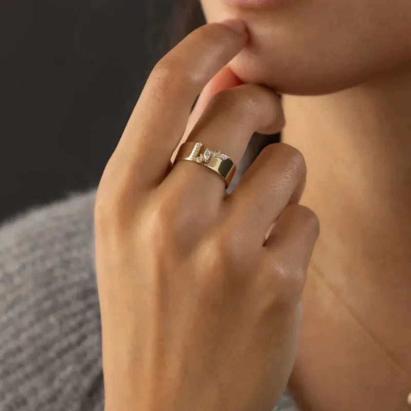Gold electroplated copper ring for women with shining zircon accents, shown on a finger.