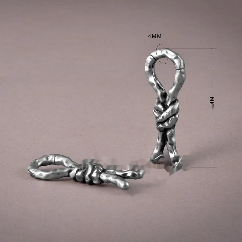 Copper bends and hitches piercing earring for auricle, showing sculptural shape and oiled finish.