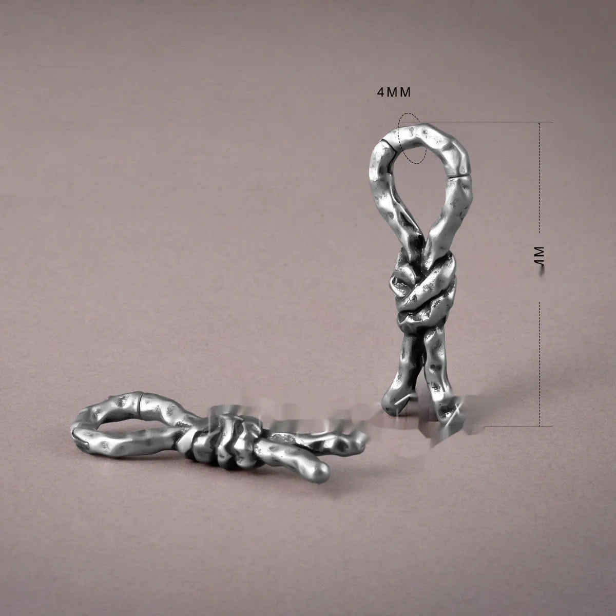 Copper bends and hitches piercing earring for auricle, showing sculptural shape and oiled finish.