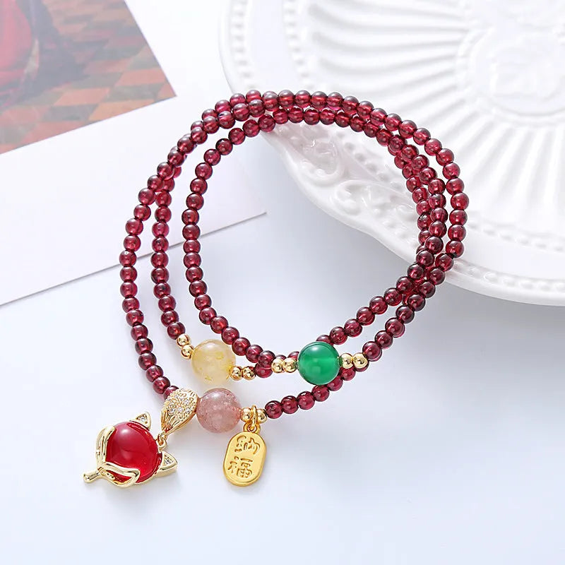 Purplish red garnet crystal fox bracelet on an adjustable rope for women.