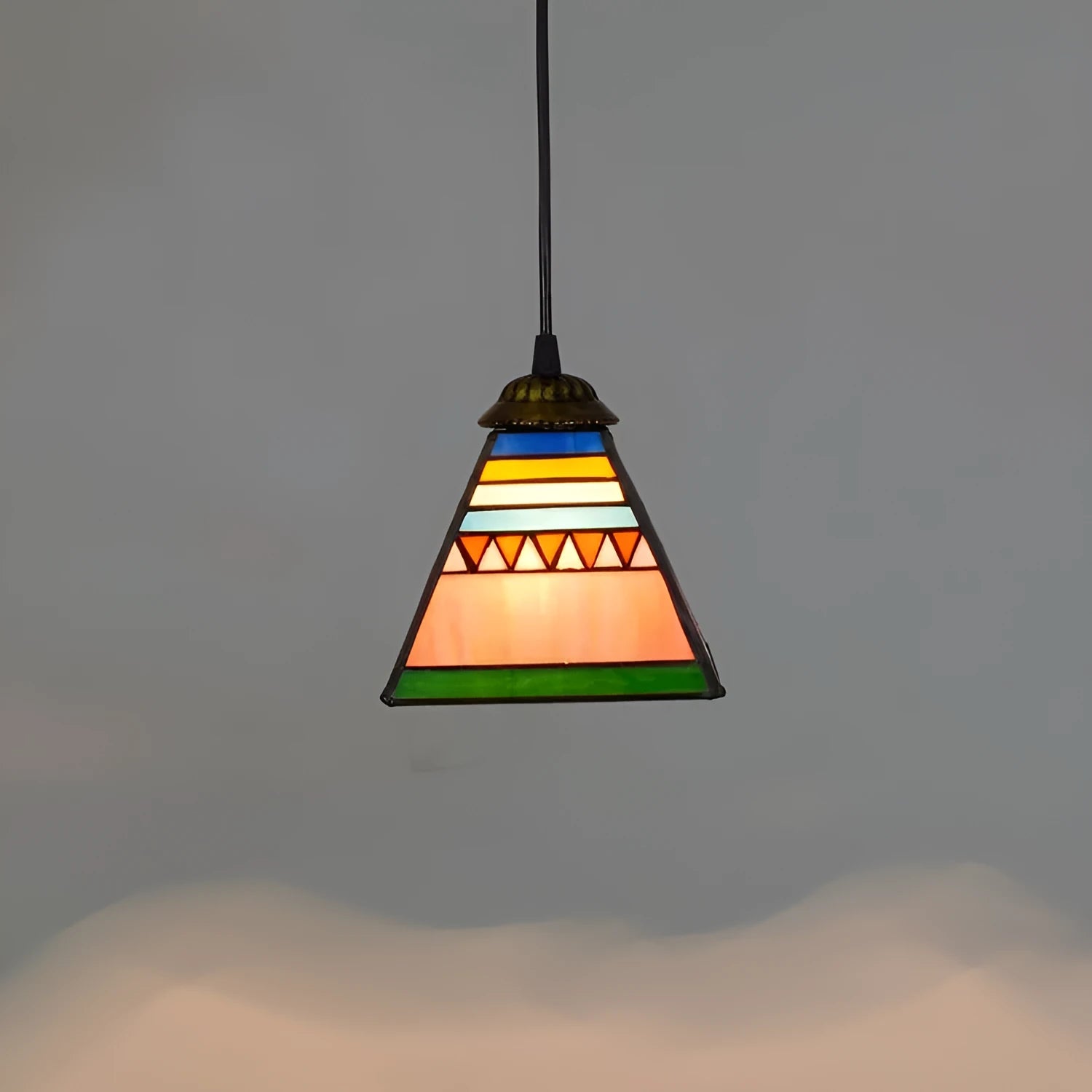 Small art stained glass droplight pendant with coloured glass shade hanging from iron ceiling plate.