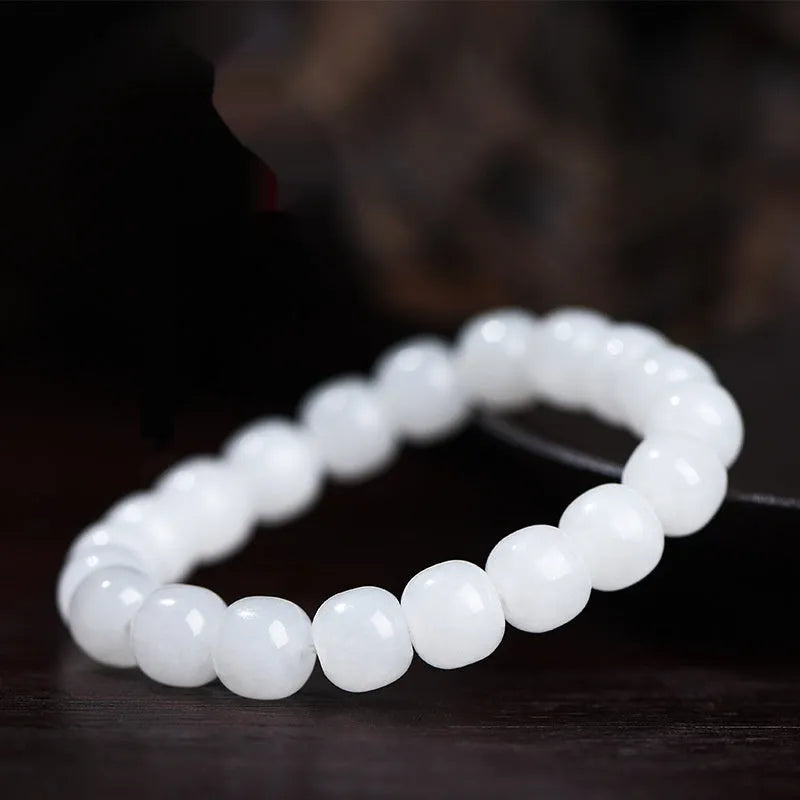 White Hetian jade barrel bead bracelet for men and women on a wrist.