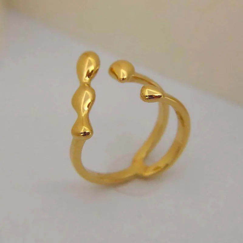 Women's brass open ring with spherical elements in gold finish showing adjustable band design
