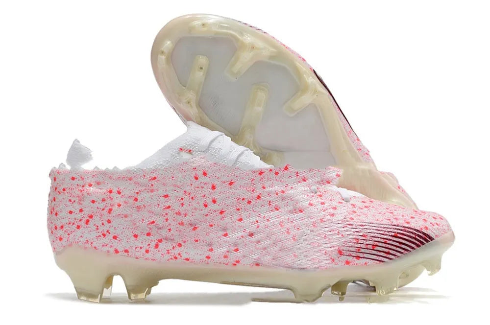 Men's low-top knitted football shoes with white sole and black upper, showing FG studs.