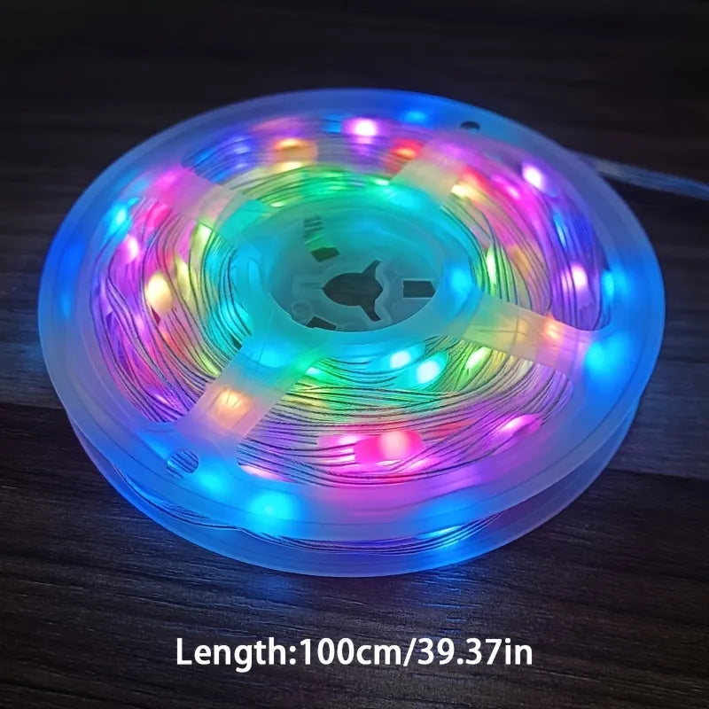 10 metre long LED festival light string with 100 warm white bulbs coiled on a table next to its remote control.