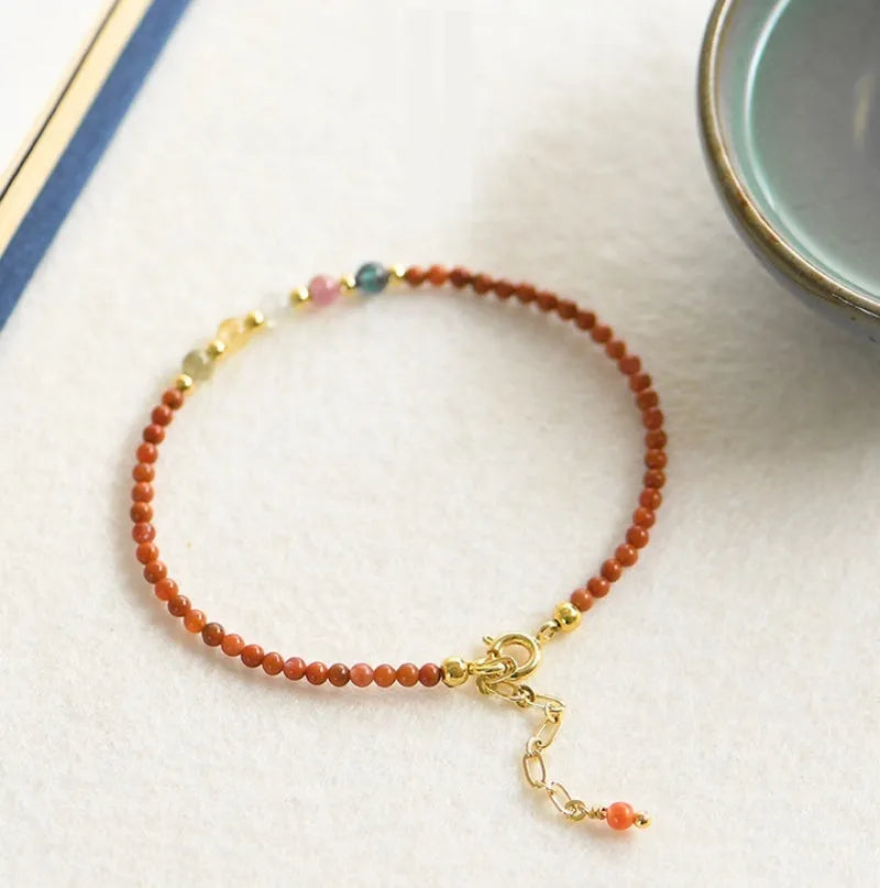 Women's freshwater pearl and geometric crystal bracelet on a black elastic braided rope.