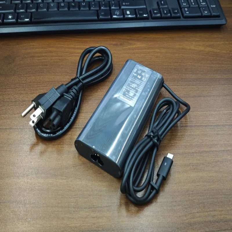 Black 65W USB-C laptop power adapter with six international plug cords for UK US EU AU SA and CN sockets